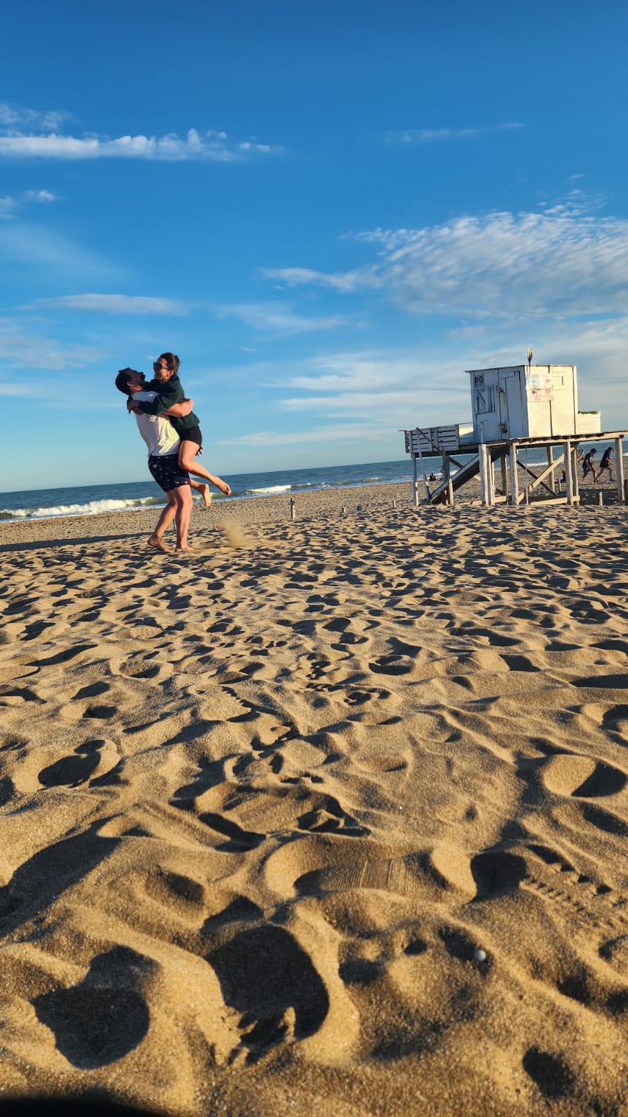 Caro y Santi saltando de alegría en la playa